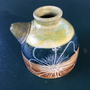 round vessel with spout and flower design