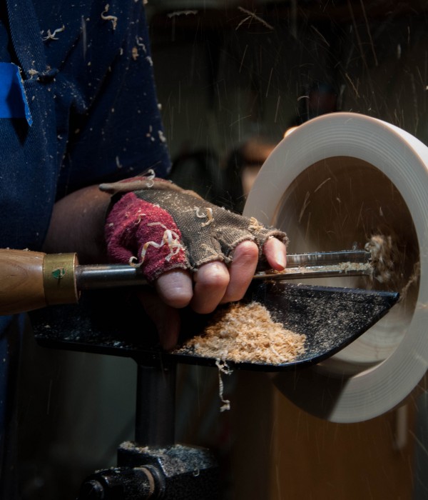 Artist turning and trimming a wooden bowl
