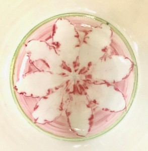 white bowl with pick flower in the center