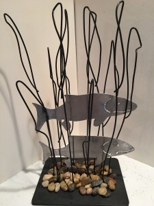 2 metal fish shapes between wire reeds