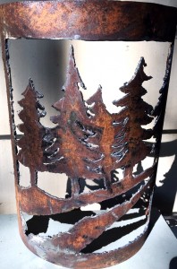 rusty metal piece with trees and creek cut in the metal
