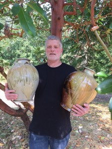 artist holding 2 large vessels