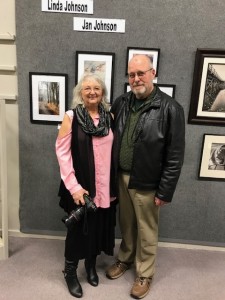 couple artists in front of their photo display