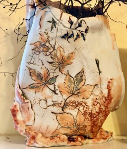 neutral colored handbuilt vessel with impressed nature images