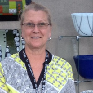 artists with glass work behind her