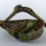 green, brown and gray woven basket with intr=egrated arched wood handle