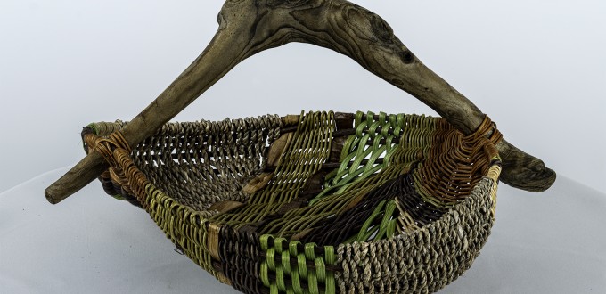 green, brown and gray woven basket with intr=egrated arched wood handle