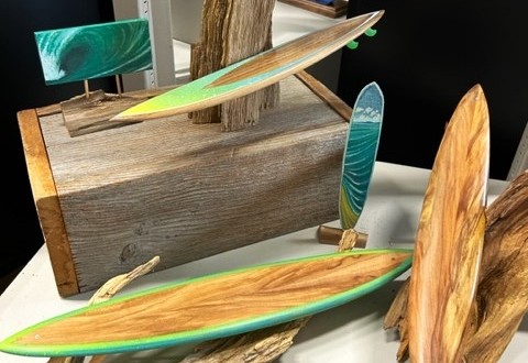 scaled models of surfbiards mounted on drift wood