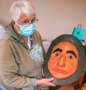 artists holding ceremonial mask