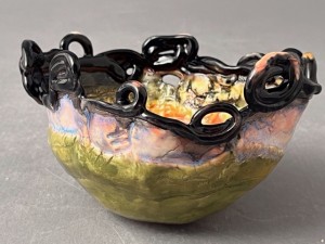 handbuilt bowl with circular shapes on the lip of the vase