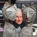 artist posed between two sculptures